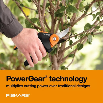 Hand using Fiskars pruning shears on a tree with PowerGear technology text below.