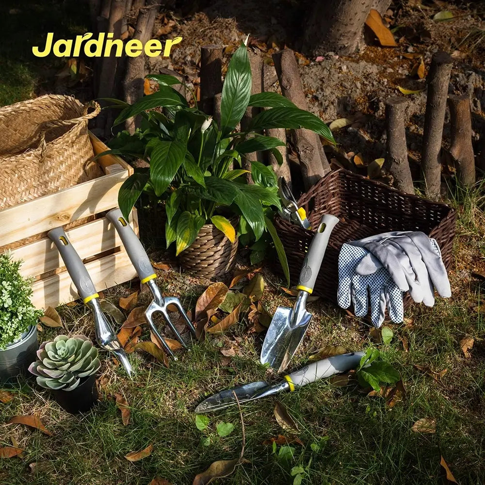 Gardening tools and gloves on a grassy area with 'Jardineer' branding.