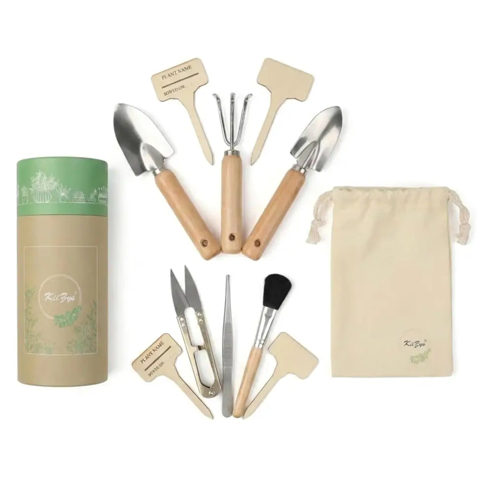 A gardening tool set with wooden-handled trowels, weeding tools, tweezers, and a brush, arranged on a white background alongside a green-and-beige cylindrical container and a beige drawstring pouch. The set appears branded with 'Kiki Bets' visible on the container and pouch.
