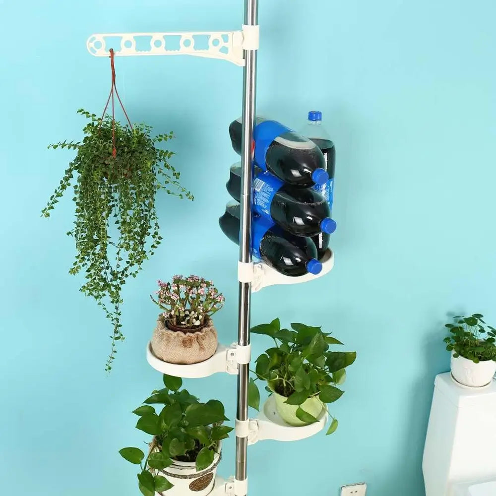 Multi-tiered plant stand with plants and bottles against a blue wall